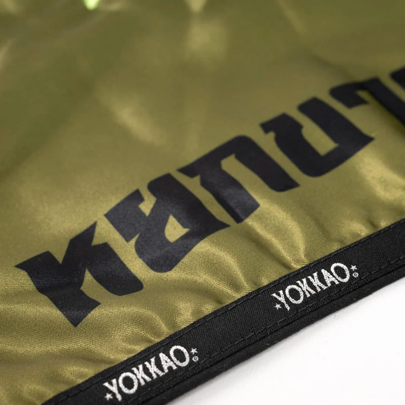 מכנסי איגרוף תאילנדי YOKKAO ירוק זית כחלק מבגדי אימון מקצועיים למתאמני מואי תאי