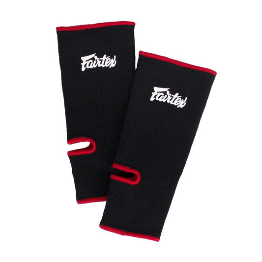 מגן קרסול Fairtex צמוד לרגל בזמן אימון מול שק איגרוף לתלייה כחלק מציוד איגרוף מלא--שחור פס אדום